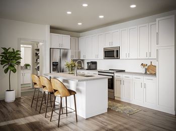 a kitchen with white cabinets and a white island with three stools